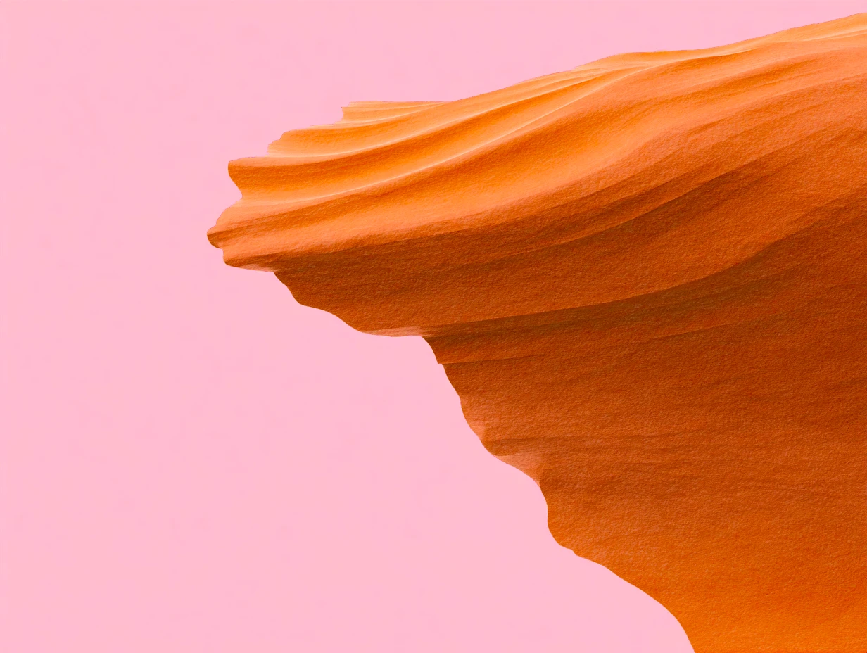 Close-up of an orange sandstone formation with smooth, wave-like curves against a pastel pink background, conveying a serene and abstract aesthetic.